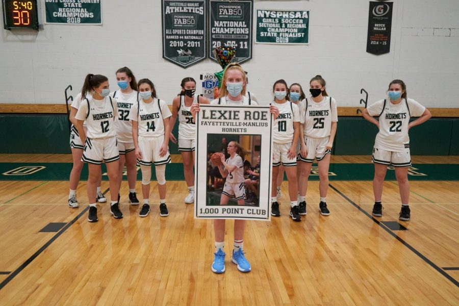 Senior Lexie Roe poses with her teammates after she scores the 1000th point in her career.
