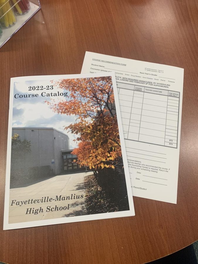 The FM High School course catalog and course schedule forms displayed on a table.