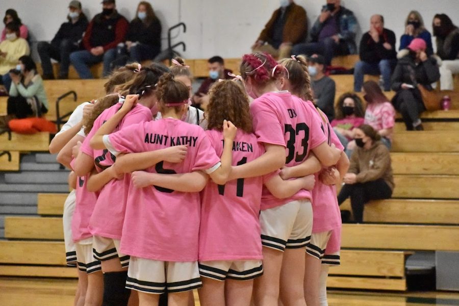 The FM girls basketball team huddles together with their Pink Out t-shirts on.