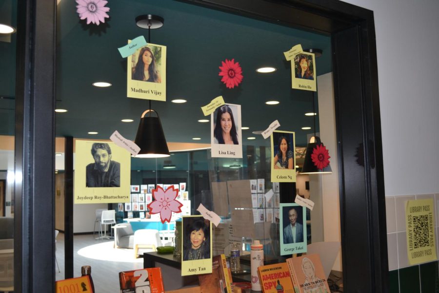 The FM High School library displays a AAPI sign with colorful flowers and pictures of prominent authors.