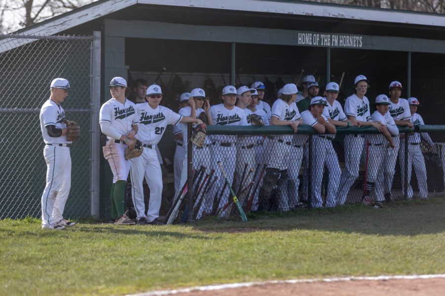 FM Baseball team poses for photographer in dugout.