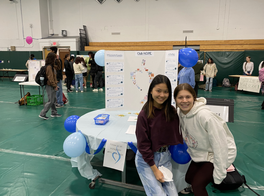 Club H.O.P.E founders Claire Lee and Sara Kronenberg pose in front of their Activities Fair poster.