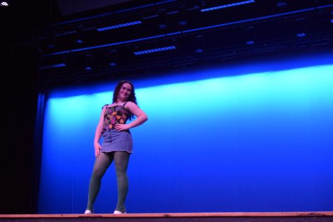 A student models her outfit--a denim skirt with a colorful sleeveless top.