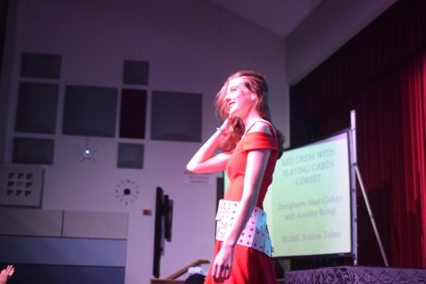 A student models her outfit--a red dress with a cumberbund made of playing cards.