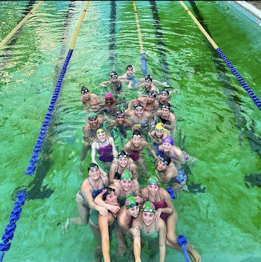 FM swimmers pose in the outdoor pool, which is green in color.