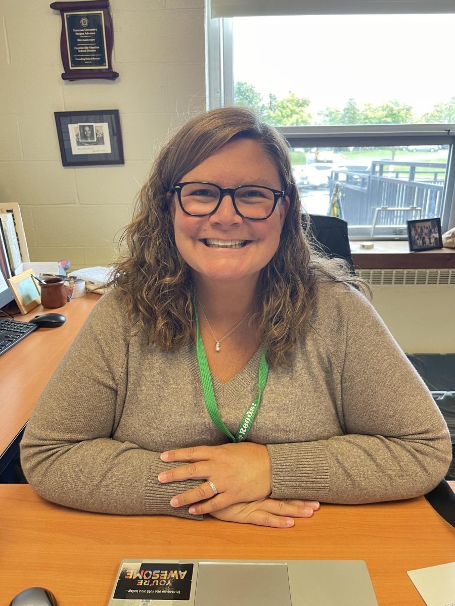 Ms. Wheeler poses at her desk with a smile.