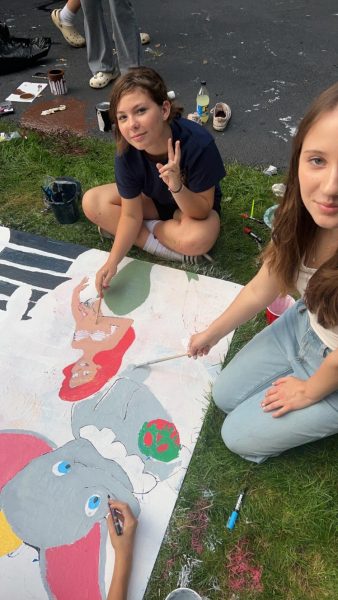 Students pose while painting their display.