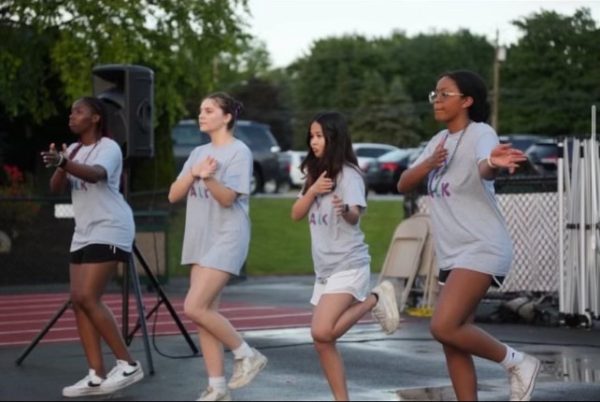 Members are lined up attempting to be in unison with their choreography.