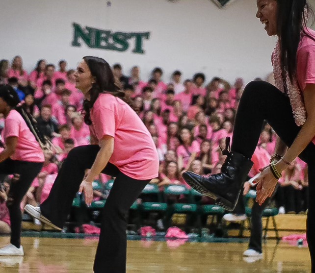 A team member dressed in pink claps between her legs during the performance at Pink Out.