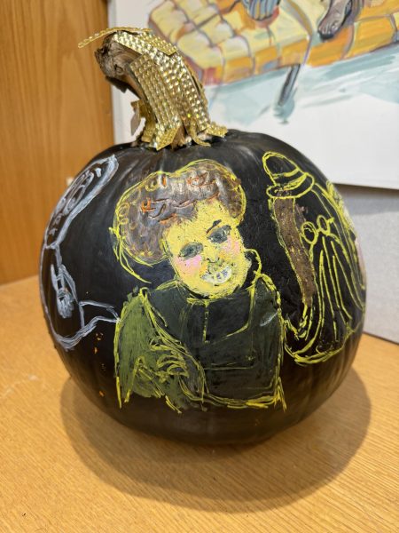 This pumpkin is painted black with a gold rhinestone stem and various Halloween figures painted on the skin.