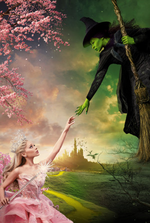 Glinda dressed in pink with a crown and sceptre reaches up to touch hands with Elphaba, green skinned and wearing black witch robes.