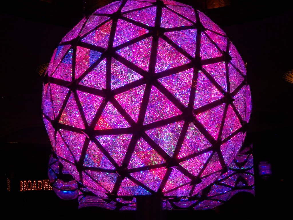 The ball is made up of triangles that are colored in shades of pink and purple.