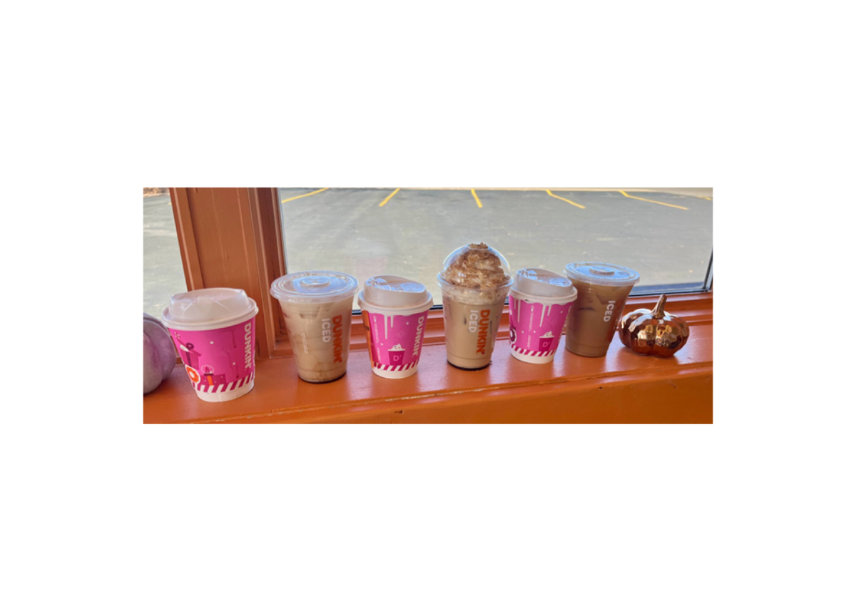 The line up of colorful drinks sits on the window sill at the store. Hot cups are a festive pink with icing dripping over the sides.