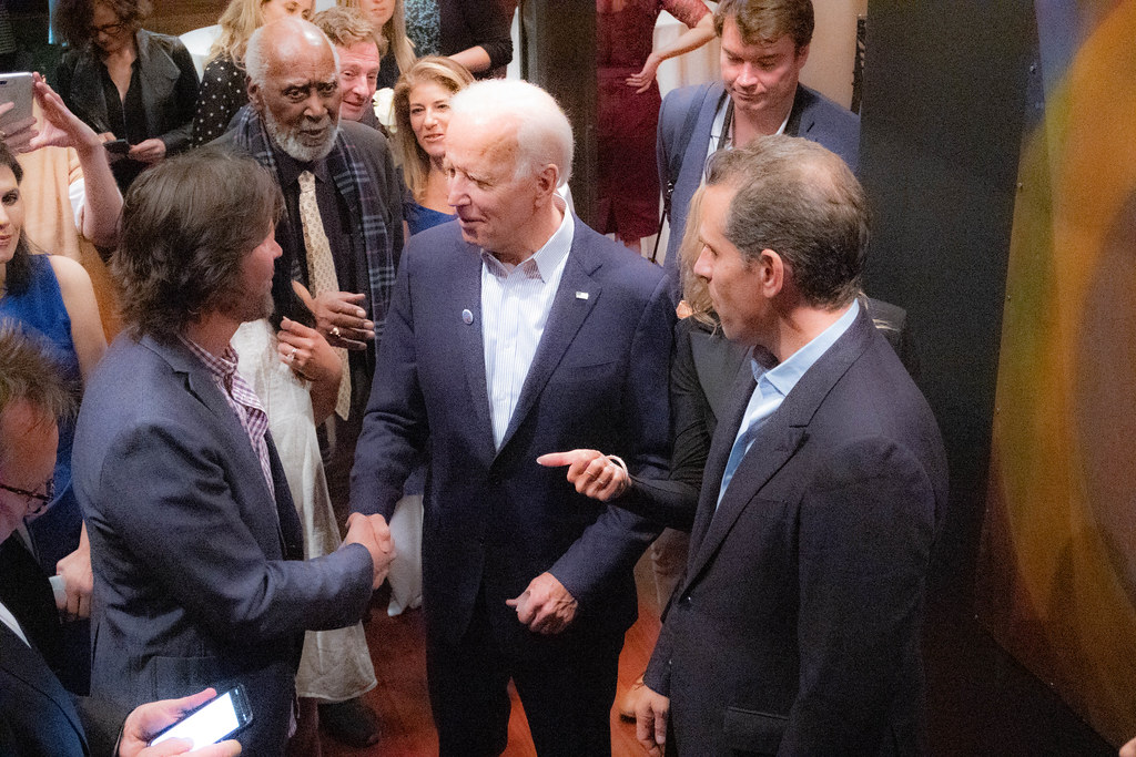 Joe Biden, accompanied by his son Hunter, shakes hand with a man at an event from 2019.