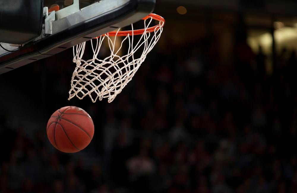 A basketball swishes through a hoop.