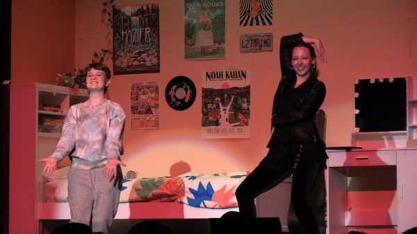 Performers dance in one of the scenes from a bedroom set on stage.