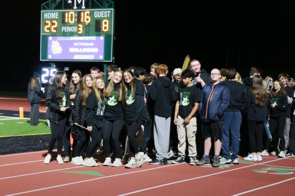 A group of students all dressed in black posed for the camera.