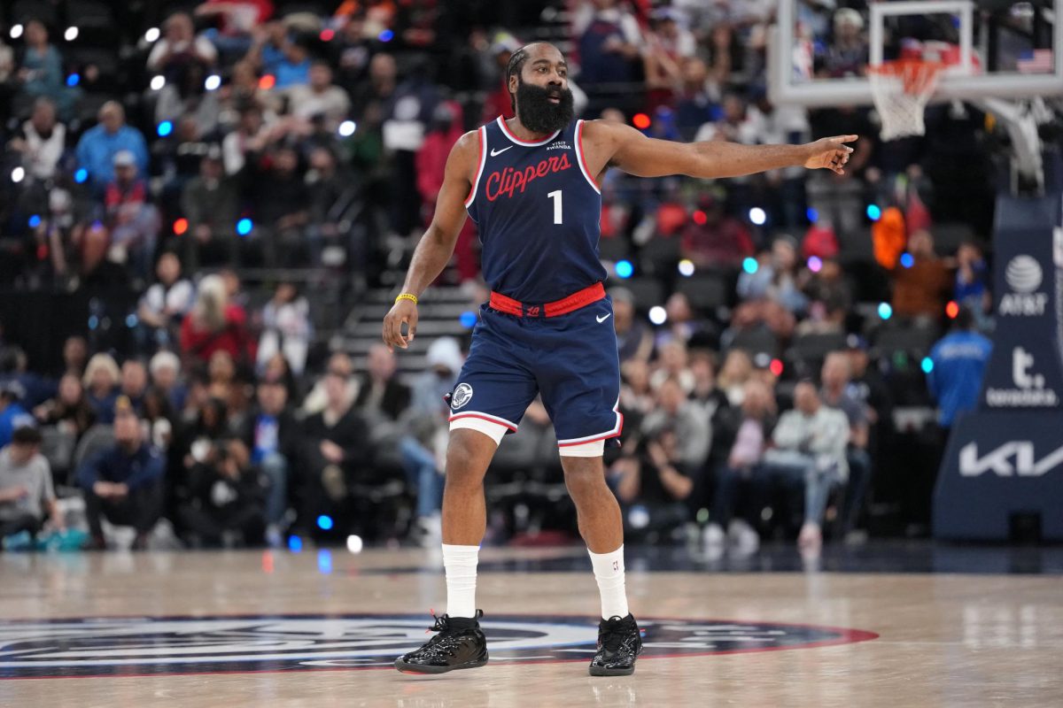 Harden, in a blue and red Clippers uniform, points to a teammate at mid-court.