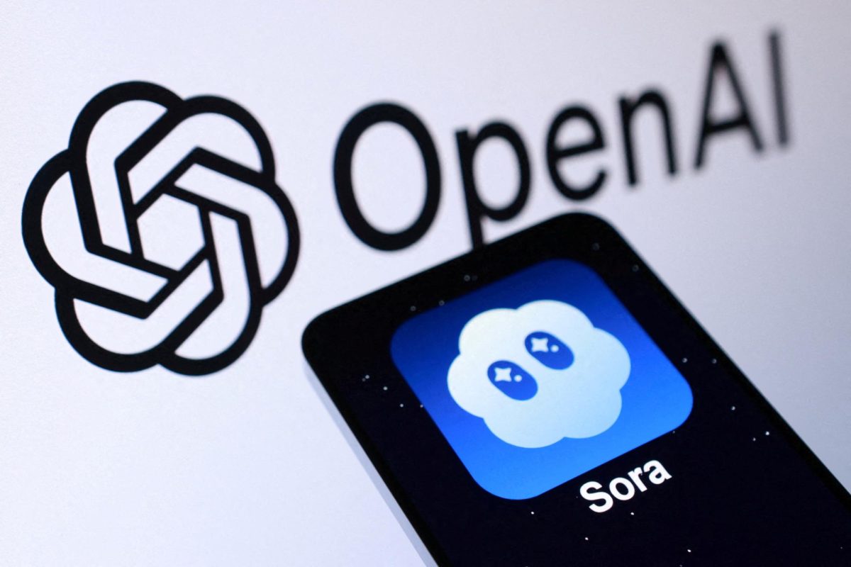 The image shows the Sora logo with its white caricature against a blue background on a phone, which rests on paper with the Open AI logo in the background.