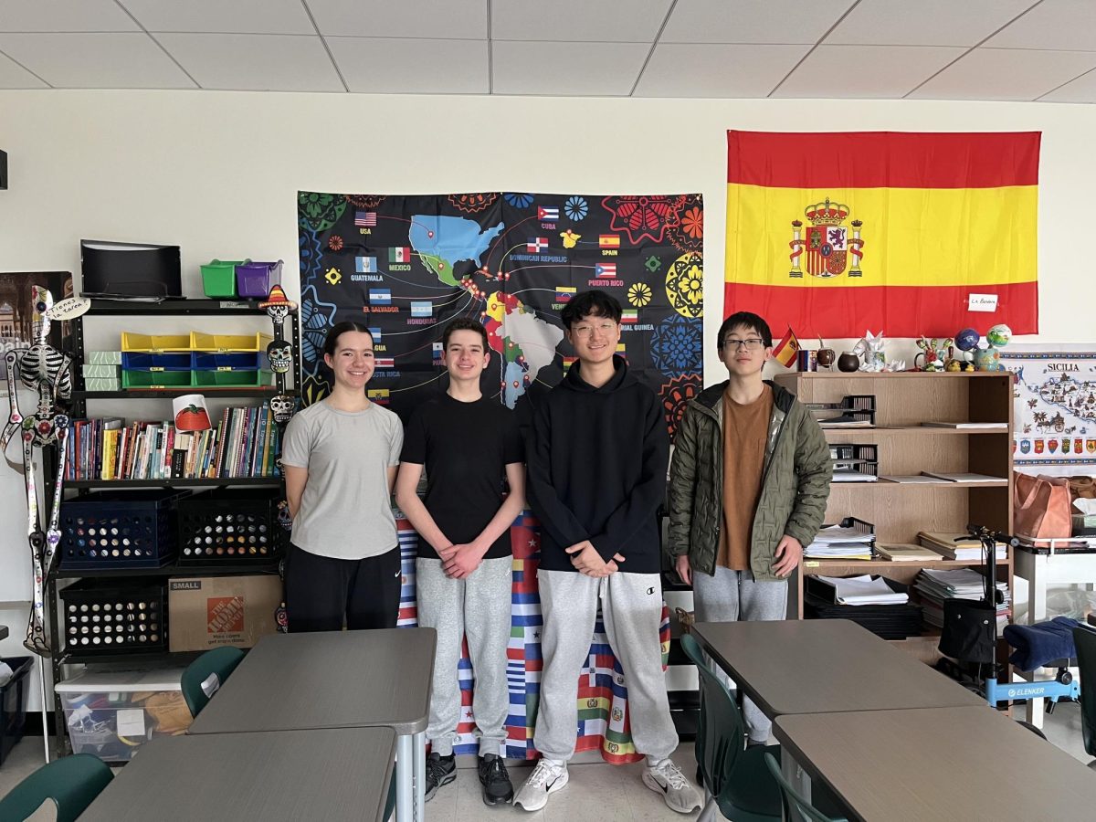 The four winners from FM pose in a classroom.