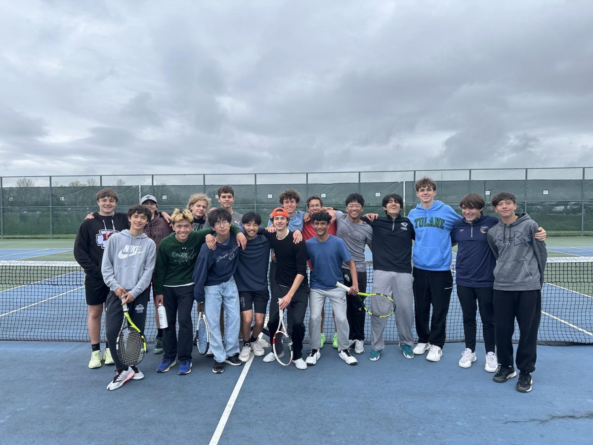 Team members pose casually on the FM tennis courts arm-in-arm.